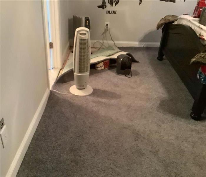 bedroom with carpet lifted for drying purposes